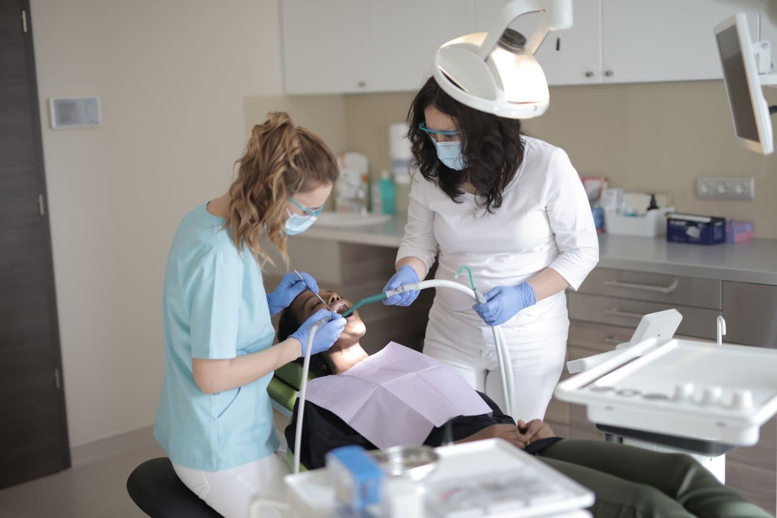 Dental clinicians performing an examination on a patient in a modern dental clinic