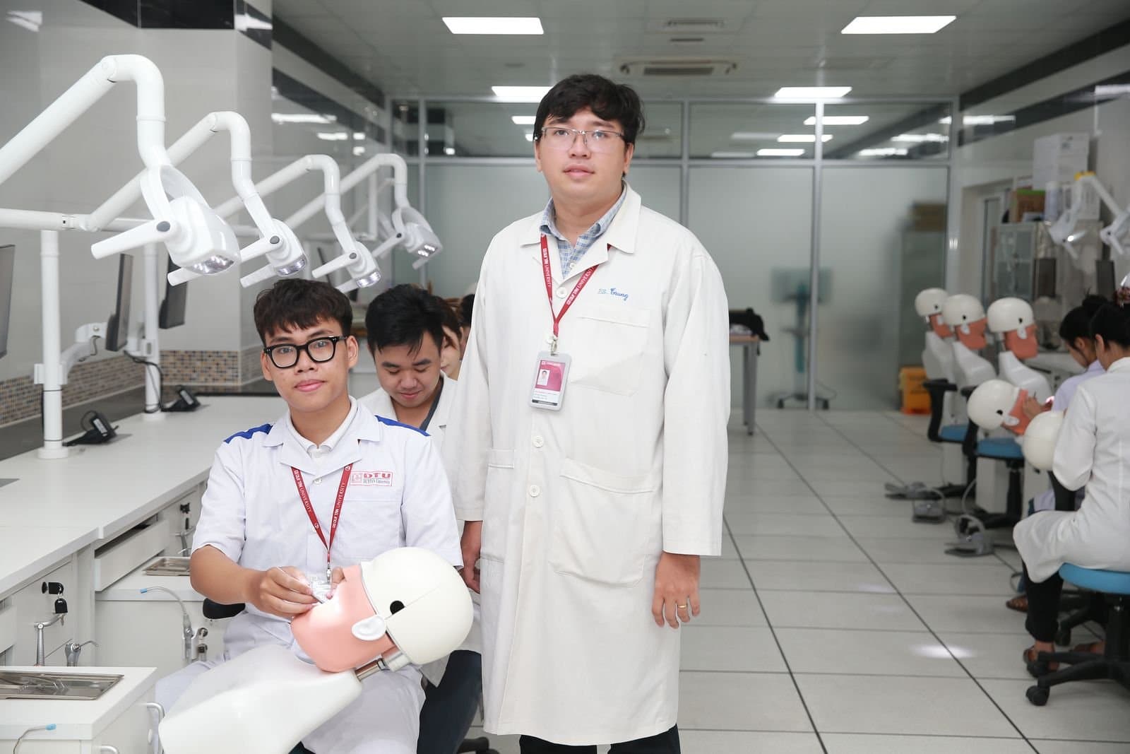 Dental students practicing clinical skills in a training lab with an instructor