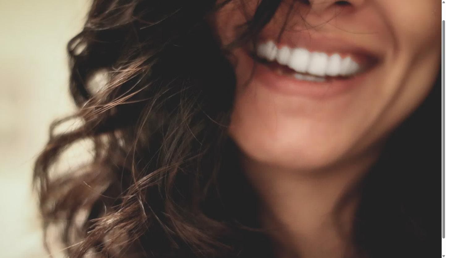 Close-up of a woman's wide, genuine smile showing her upper teeth and gumline