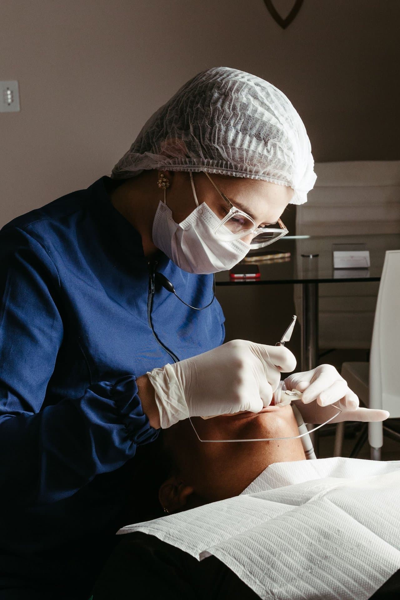 Dentist and assistant performing a dental surgical procedure, representing wisdom tooth extraction